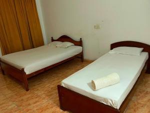 two beds in a small room at Mimosha holiday inn in Godapola