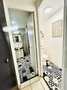 ein Badezimmer mit schwarz-weiß gefliestem Boden in der Unterkunft Le cottage in Saint-Brieuc