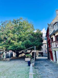 ein Baum neben einem Gebäude und einer Straße in der Unterkunft Le cottage in Saint-Brieuc