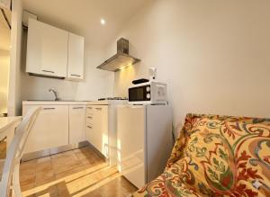 une petite cuisine avec un micro-ondes au-dessus d'un réfrigérateur dans l'établissement 8 ARBOUSIERS VILLA 20, à Bonifacio