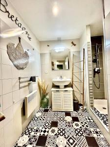 ein Badezimmer mit schwarz-weiß gefliestem Boden in der Unterkunft Le cottage in Saint-Brieuc