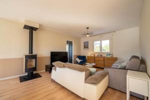 a living room with a couch and a fireplace at La Villa Océane, familiale & piscine privée in Guidel
