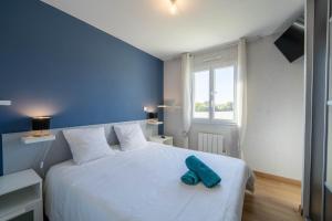 a bedroom with a white bed with a blue wall at La Villa Océane, familiale & piscine privée in Guidel +50 photos