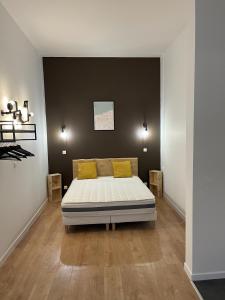 a bedroom with a bed with yellow pillows on it at Calais Wilson 2 - Studio Balneo 2p in Calais