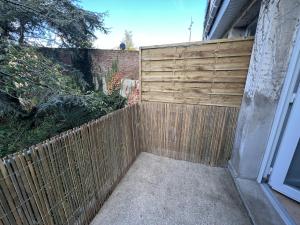 a backyard with a wooden fence next to a house at Calais Wilson 2 - Studio Balneo 2p in Calais