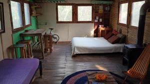 a bedroom with a bed and a table in a room at Espacio Las Abejas Cabaña Las Abejas in Tigre +13 photos