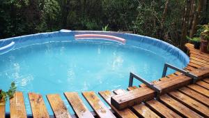 a large swimming pool with a wooden bench next to it at Espacio Las Abejas Cabaña Las Abejas in Tigre