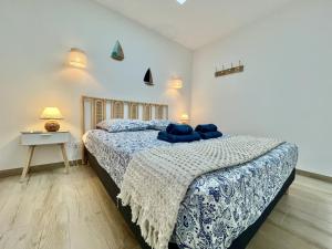 ein Schlafzimmer mit einem Bett mit blauen Kissen darauf in der Unterkunft Rincon del Mar - Maison & spa privatif in Saint-Hilaire-de-Riez + 18 Fotos