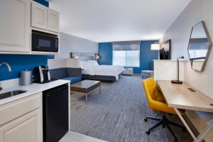a hotel room with a kitchen and a living room at Holiday Inn Express & Suites Sioux Falls Southwest by IHG in Sioux Falls