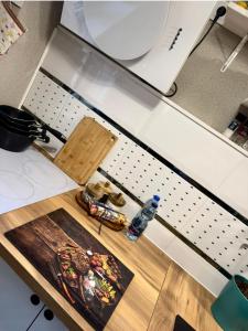 a kitchen counter with a cutting board and a bottle of water at Apartament Majowa in Jelenia Góra +54 photos