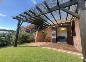 une pergola au-dessus d'un patio dans une cour dans l'établissement 8 ARBOUSIERS VILLA 21, à Bonifacio