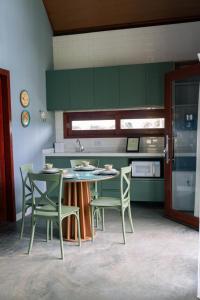 une cuisine avec des armoires vertes et une table et des chaises dans l'établissement Ecoville Coracao da Serra, à Areia