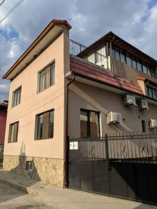 a large house with a black gate in front of it at Къща за гости Семейство Петрови in Kalofer