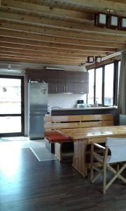 a kitchen with a wooden table and a refrigerator at Къща за гости Семейство Петрови in Kalofer