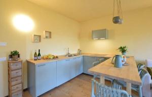 a kitchen with white cabinets and a table with a sink at House in the Shambhalla Forest in Esmate