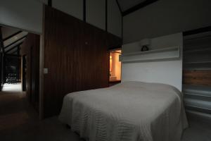 ein Schlafzimmer mit einem weißen Bett in einem Zimmer in der Unterkunft Cabaña estilo escandinavo in Santa Ana