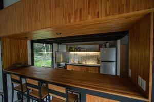 a kitchen with a counter with chairs and a refrigerator at Cabaña estilo escandinavo in Santa Ana
