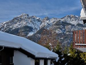 a snow covered mountain in front of a house at Bader Suites in Garmisch-Partenkirchen