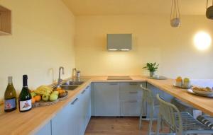 a kitchen with a counter with a bowl of fruit and wine bottles at House in the Shambhalla Forest in Esmate