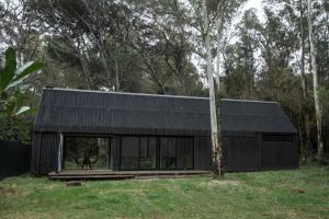 ein schwarzes Haus mit schwarzem Dach in der Unterkunft Cabaña estilo escandinavo in Santa Ana + 18 Fotos