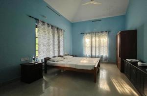 Un dormitorio con una cama en una habitación azul. en Aquatica by bough'n villa, en Kenichira