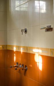 y baño con ducha con azulejos de color naranja y blanco. en Aquatica by bough'n villa, en Kenichira