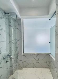 una ducha con puerta de cristal en un baño en The Pyramid Vault View INN, en El Cairo