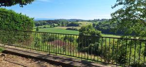 a balcony with a view of a field and trees at studio indépendant dans maison à la campagne in Lagor