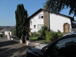 a white house with a car parked in front of it at Im Vulkanland Fewo bis 6 Personen in Ettringen
