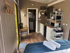 a small room with a bed and a kitchen at Gruyere Falls by Tiny Away in Gruyere