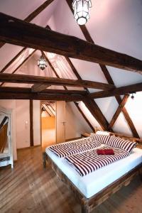 a large bed in a room with wooden beams at RefuKium alte Gerberei - Im Zentrum von Weißenburg in Weißenburg in Bayern