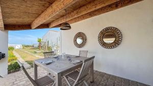 comedor con mesa y 2 espejos en Charmante location à deux pas de la plage, en Rivedoux-Plage