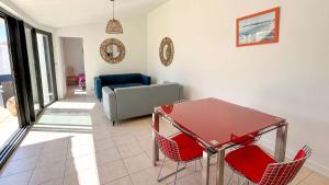sala de estar con mesa roja y sillas en Charmante location à deux pas de la plage, en Rivedoux-Plage