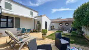 un patio con sillas y mesas en Charmante location à deux pas de la plage, en Rivedoux-Plage