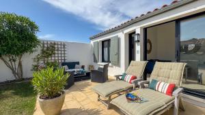 un patio con dos sillas y una mesa en Charmante location à deux pas de la plage, en Rivedoux-Plage 9 fotos más