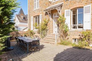 een terras met een tafel en stoelen voor een gebouw bij Villa des Genêts in Saint-Pair-sur-Mer