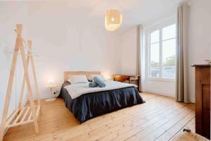 een slaapkamer met een bed en een ladder erin bij Villa des Genêts in Saint-Pair-sur-Mer