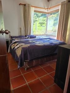 a bedroom with a bed with a large window at Finca santa helena in Machetá