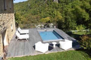 a swimming pool on a wooden deck with two chairs at La Grange de Magdeleine in Salles-la-Source +19 photos