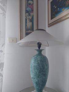 a green vase sitting on a table with a lamp at Al borgo di capomulini in Acireale