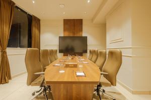 a conference room with a large wooden table and chairs at Olwen Suites in Cochin