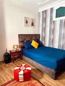 a bedroom with a blue bed and a red ottoman at Quiet Private Room in Tiznit in Tiznit