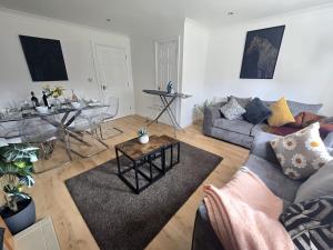 a living room with a couch and a table at 2ndHomeStays- Bilston- Contractors Friendly Townhouse in Bilston