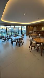 ein Esszimmer mit Tischen und Stühlen und Fenstern in der Unterkunft Apartamento 2 quartos na orla de Aracaju 2 in Aracaju