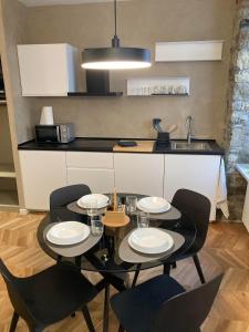 a dining room table with chairs and a kitchen at Trieste City 1 in Trieste