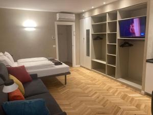 a living room with a couch and a tv at Trieste City 1 in Trieste