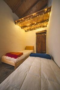 a bedroom with two beds with lights on the ceiling at Casa Sorel : Attico Lago & Pool in Pianello Del Lario