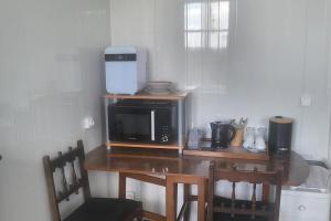 a kitchen with a microwave and a table with chairs at 1Bed Apartment Sleeps 2 - Parking Wifi in Fougerolles-du-Plessis