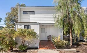 a white house with a white door and trees at Beach Shack 6 in Preston Beach