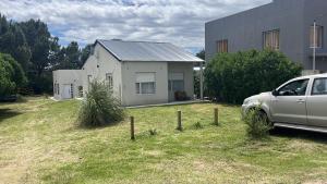 Un coche blanco aparcado delante de una casa en Cabañas del monte, en Monte Hermoso
